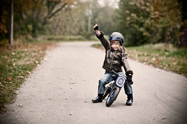 Little girl in helmet winning a balance bike race